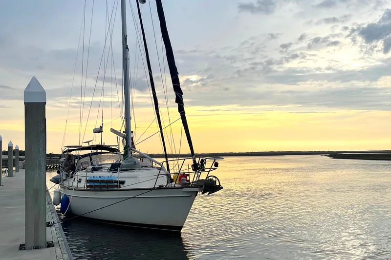 Slide: The Image of Sailboat Island Packet 380, 2001 model, docked at sunset with calm waters. - 47