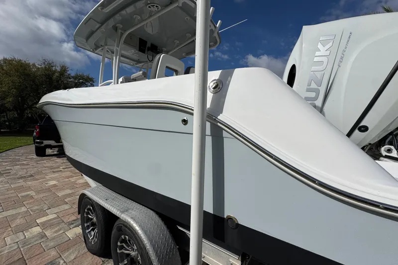 Slide: The Image of 2022 Aquasport 2500 Center Console boat on trailer, featuring Suzuki outboard motor. - 10