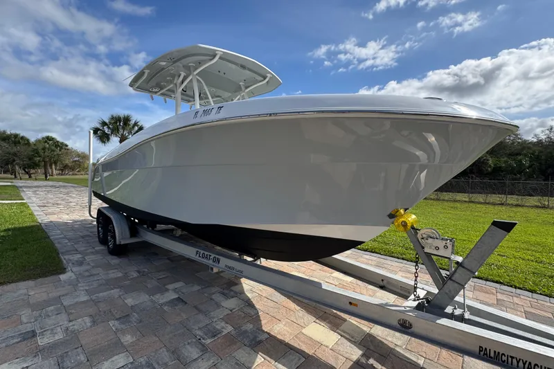 Slide: The Image of 2022 Aquasport 2500 Center Console boat on trailer, parked on paved driveway. - 11