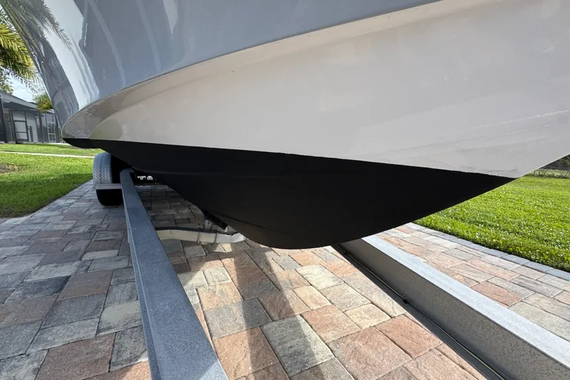 Slide: The Image of 2022 Aquasport 2500 Center Console boat on trailer, close-up view of hull. - 12