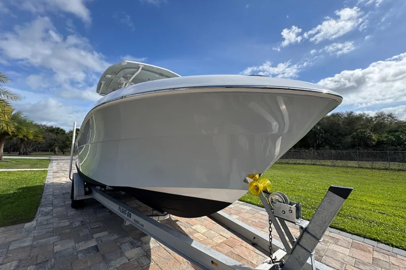 Slide: The Image of 2022 Aquasport 2500 Center Console boat on trailer, under a clear blue sky. - 13