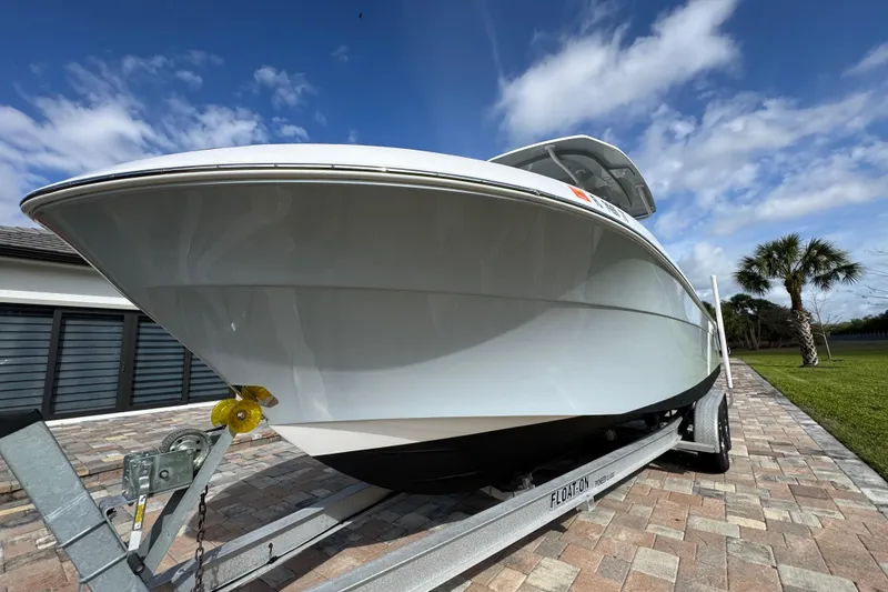 Slide: The Image of 2022 Aquasport 2500 Center Console boat on trailer, parked on brick driveway. - 14