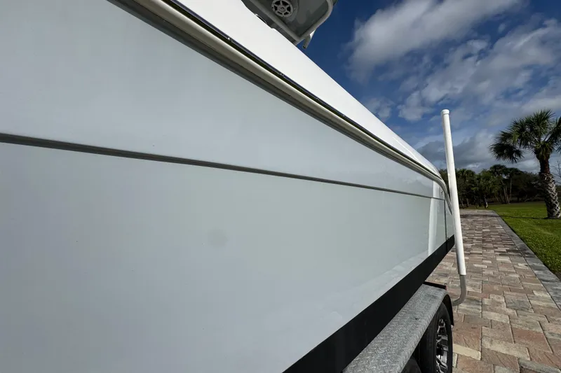 Slide: The Image of 2022 Aquasport 2500 Center Console boat on trailer, under blue sky. - 16