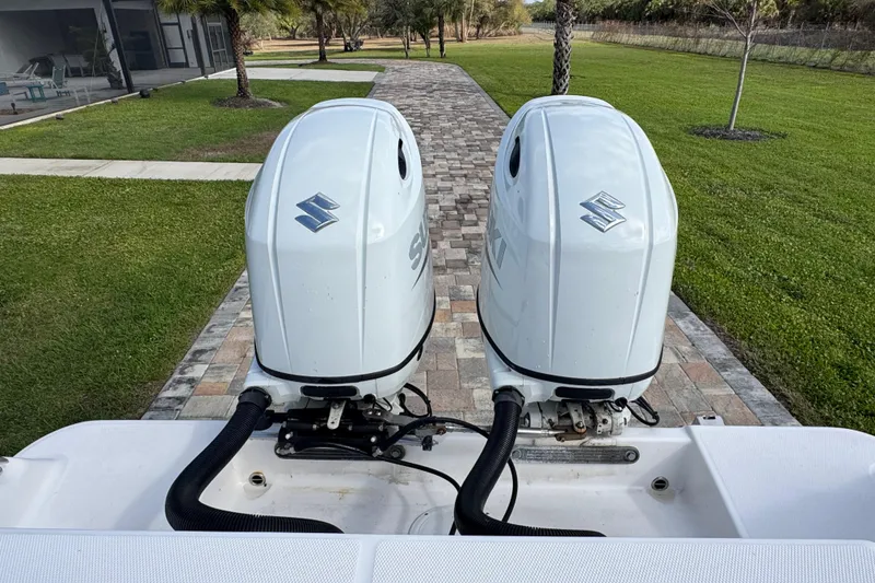 Slide: The Image of Twin Suzuki outboard motors on a 2022 Aquasport 2500 Center Console boat. - 18