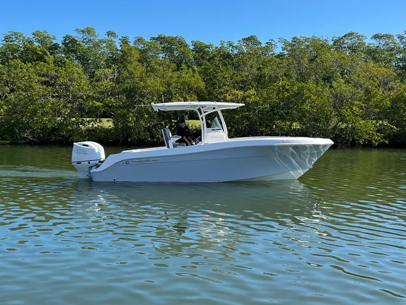 Slide: The Image of 2022 Aquasport 2500 Center Console on calm water. - 2