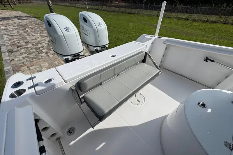 Slide: The Image of 2022 Aquasport 2500 Center Console boat with dual Suzuki engines and seating area. - 22