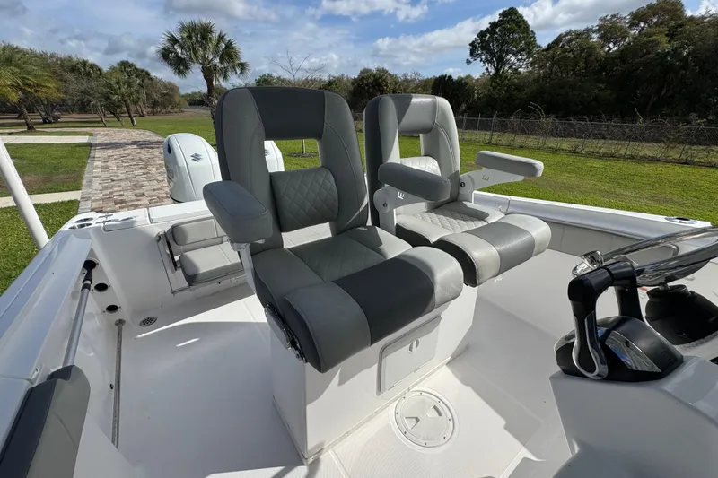 Slide: The Image of 2022 Aquasport 2500 Center Console boat with dual seating and lush green surroundings. - 26