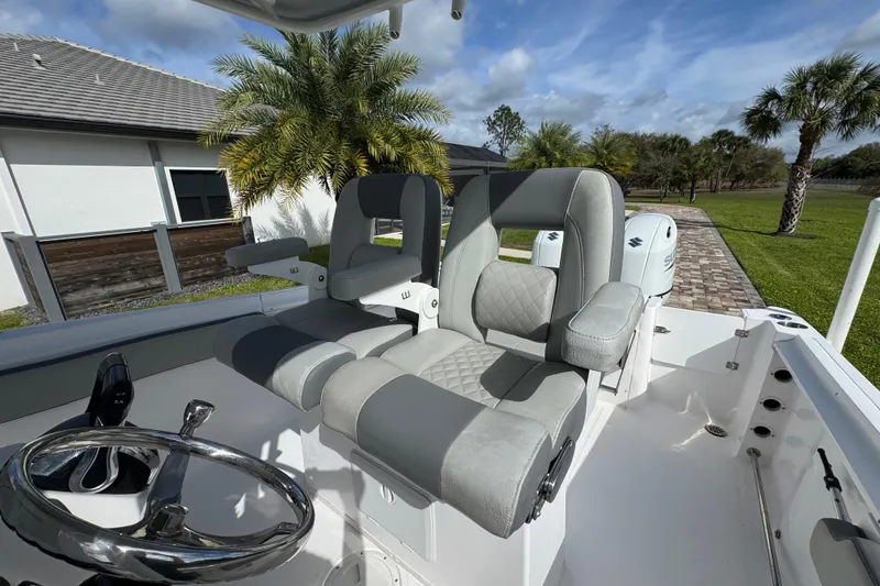 Slide: The Image of 2022 Aquasport 2500 Center Console boat with dual seats and steering wheel, outdoor setting. - 27
