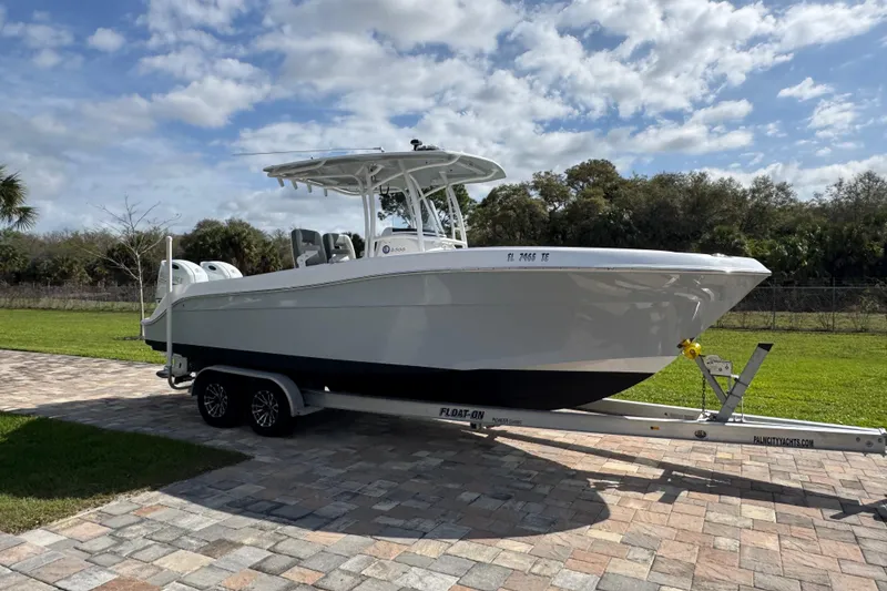 Slide: The Image of 2022 Aquasport 2500 Center Console boat on trailer, parked on paved driveway. - 3
