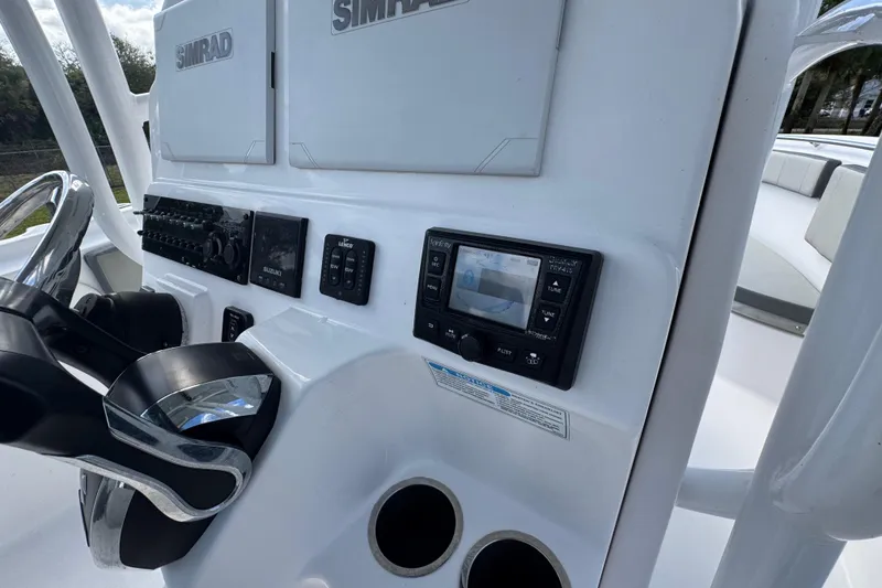 Slide: The Image of 2022 Aquasport 2500 Center Console dashboard with Simrad electronics and steering wheel. - 30