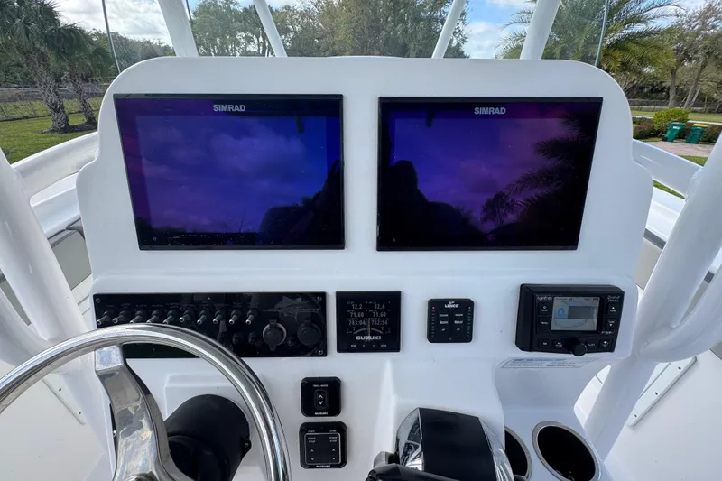 Slide: The Image of Control panel of 2022 Aquasport 2500 Center Console with dual Simrad displays. - 32