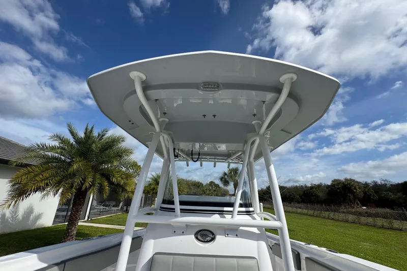 Slide: The Image of 2022 Aquasport 2500 Center Console boat with T-top against a blue sky backdrop. - 38