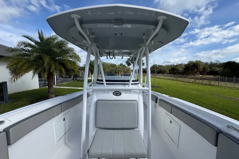 Slide: The Image of 2022 Aquasport 2500 Center Console boat with T-top, parked near palm trees. - 39