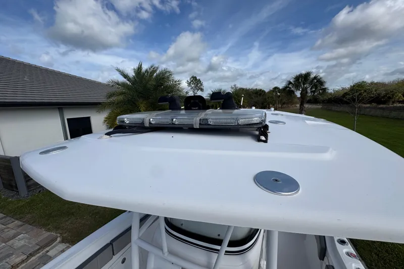 Slide: The Image of 2022 Aquasport 2500 Center Console boat with rooftop view, featuring mounted lights. - 40