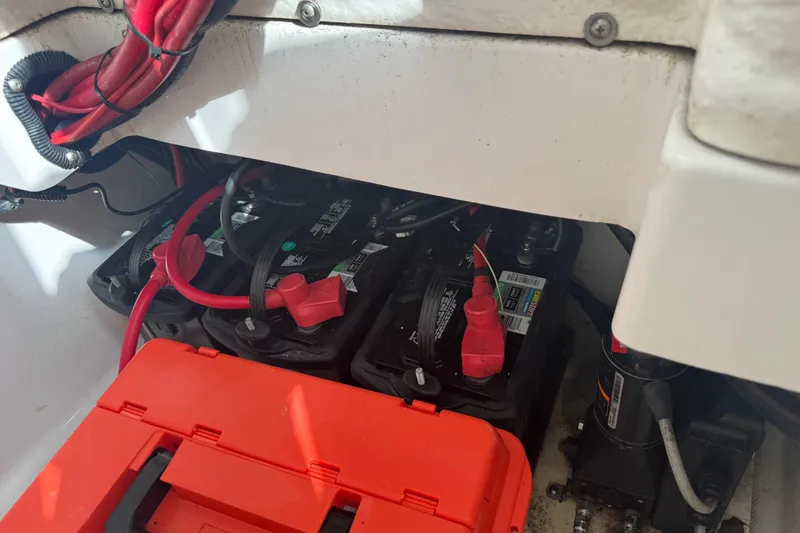Slide: The Image of Battery compartment of 2022 Aquasport 2500 Center Console with red cables and orange cover. - 41