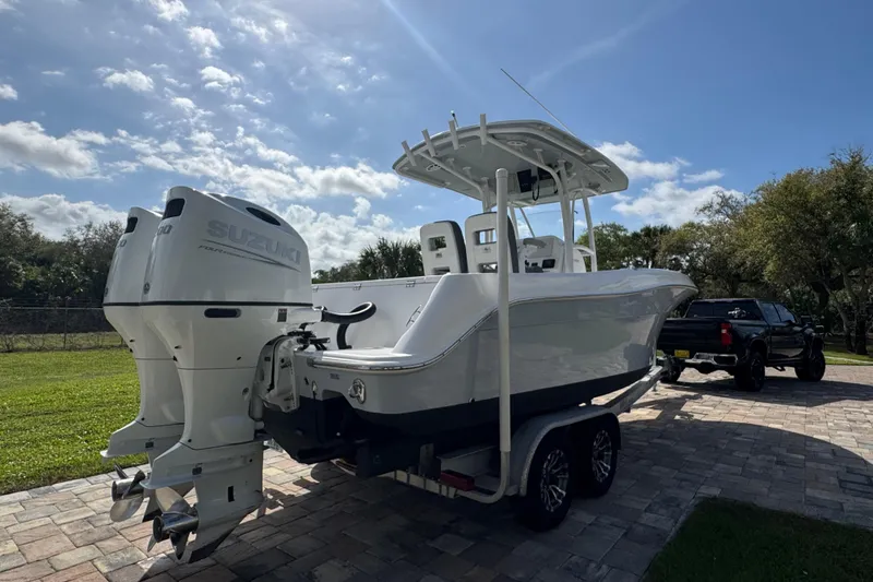 Slide: The Image of 2022 Aquasport 2500 Center Console boat with dual Suzuki engines on a trailer. - 5