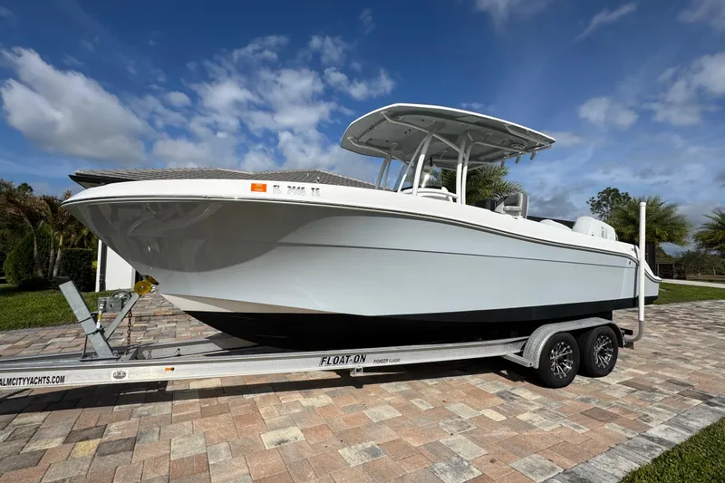 Slide: The Image of 2022 Aquasport 2500 Center Console boat on trailer, parked on a sunny driveway. - 7