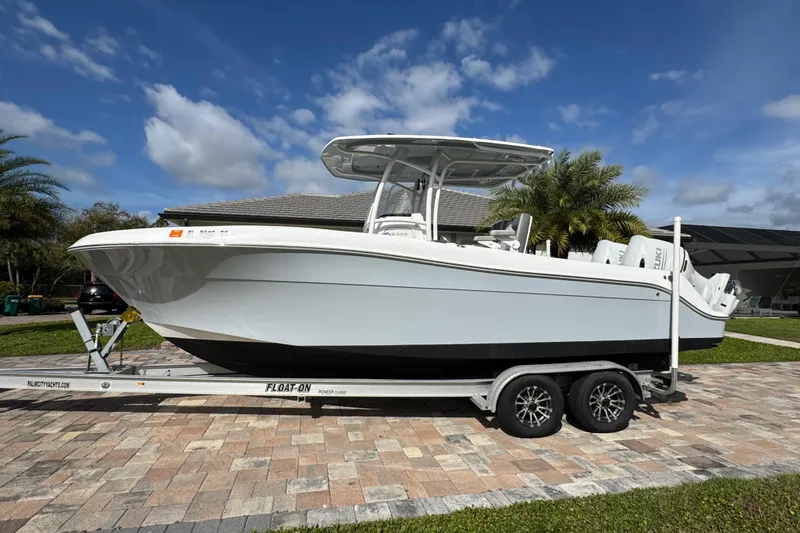Slide: The Image of 2022 Aquasport 2500 Center Console boat on trailer, parked on a paved driveway. - 8