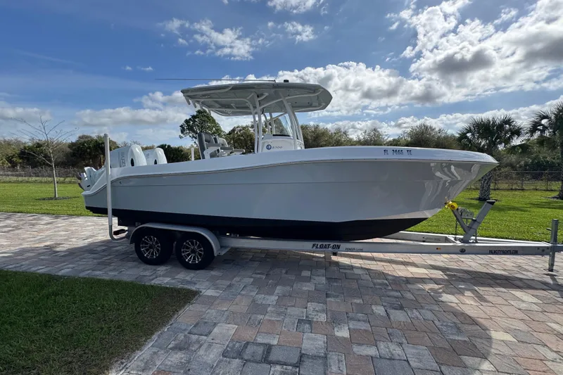 Slide: The Image of 2022 Aquasport 2500 Center Console boat on trailer, parked on paved driveway. - 9