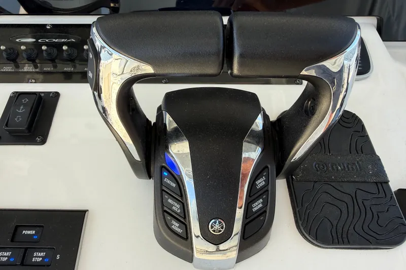 Slide: The Image of Throttle controls on a 2023 Cobia 350 Center Console boat dashboard. - 15