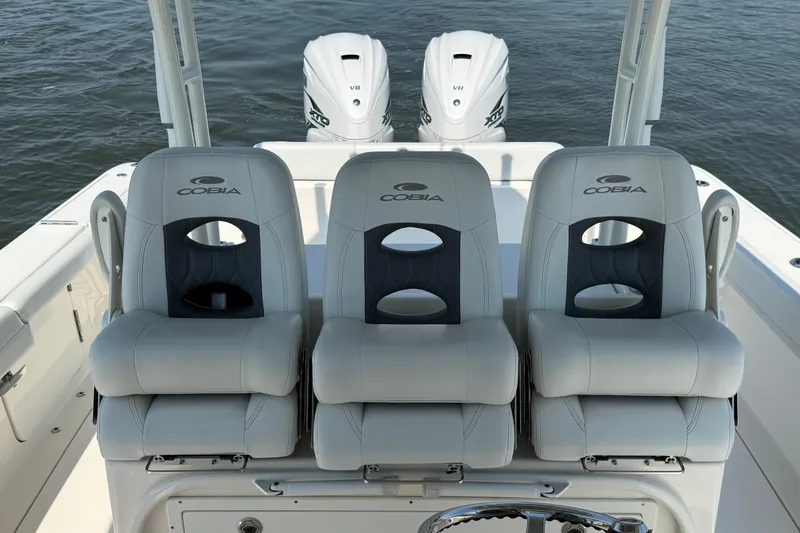 Slide: The Image of 2023 Cobia 350 Center Console boat seats with dual outboard engines on water. - 22