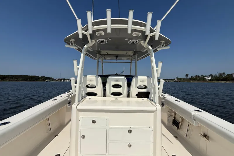Slide: The Image of 2023 Cobia 350 Center Console boat on calm water, showcasing spacious deck and seating. - 23