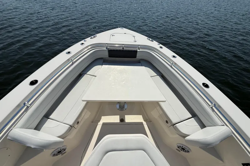 Slide: The Image of 2023 Cobia 350 Center Console boat interior with seating and table on calm water. - 28