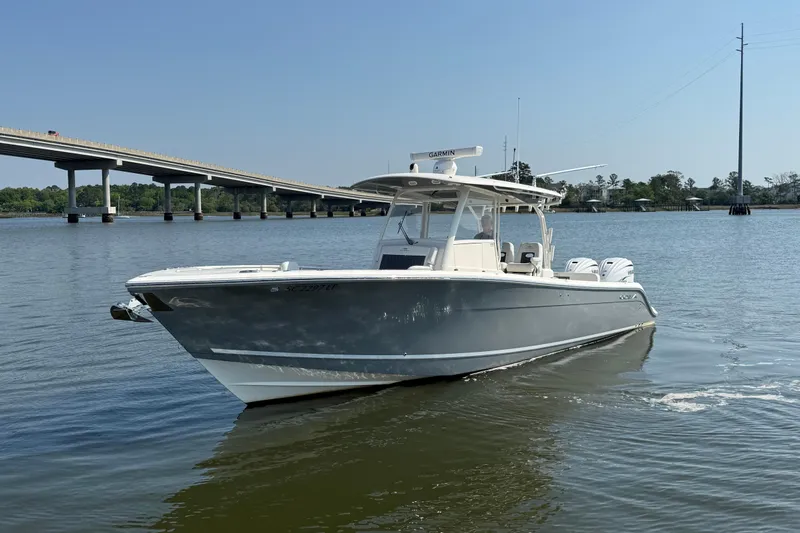 Slide: The Image of 2023 Cobia 350 Center Console boat on calm water near a bridge. - 3