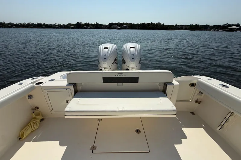 Slide: The Image of 2023 Cobia 350 Center Console boat with twin engines on a calm lake. - 36