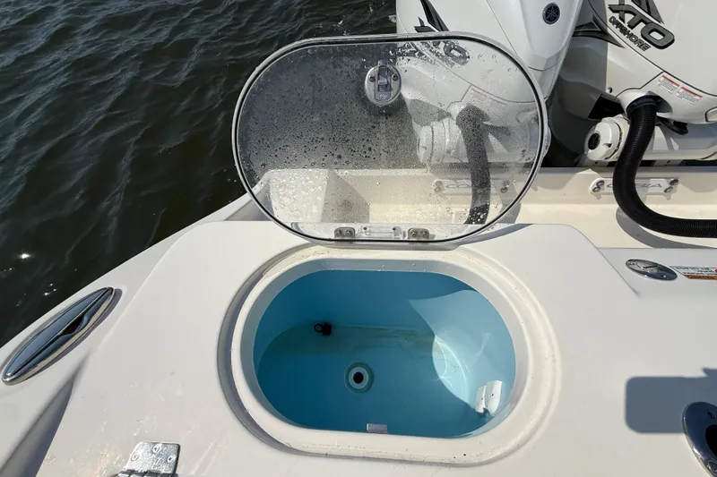 Slide: The Image of 2023 Cobia 350 Center Console livewell with open lid, near water. - 37