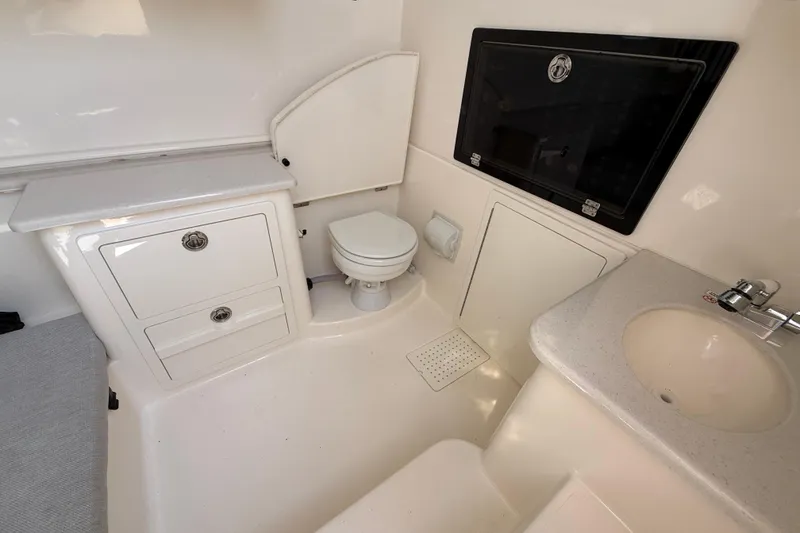 Slide: The Image of 2023 Cobia 350 Center Console boat interior with toilet, sink, and storage cabinets. - 39