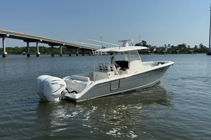 Slide: The Image of 2023 Cobia 350 Center Console boat on water near a bridge, featuring Yamaha engines. - 4