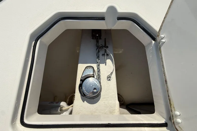 Slide: The Image of Anchor compartment of 2023 Cobia 350 Center Console boat, featuring chain and winch. - 42