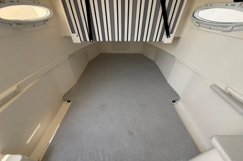 Slide: The Image of 2023 Cobia 350 Center Console cabin interior with striped ceiling and circular windows. - 43