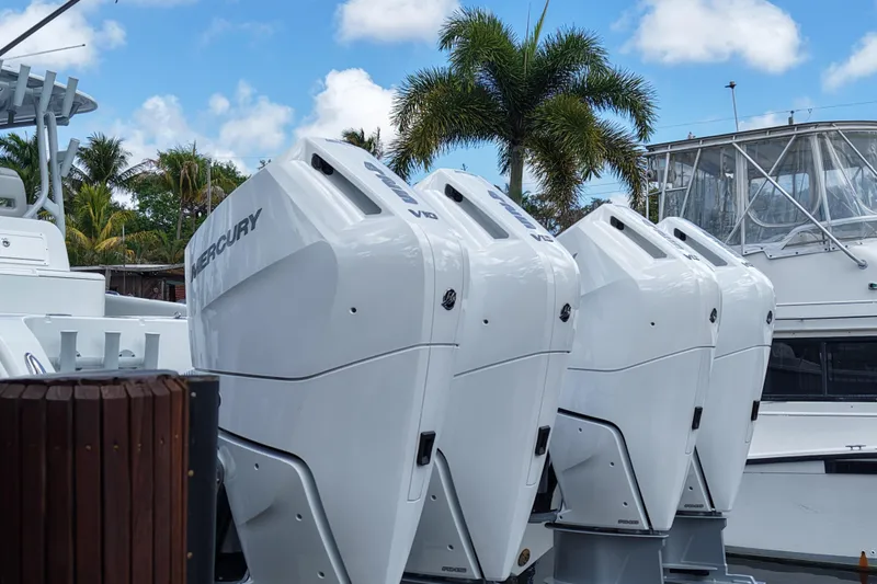 The Image of Four Mercury outboard engines on a Freeman 42LR boat, 2021 model, docked with palm trees. - 1