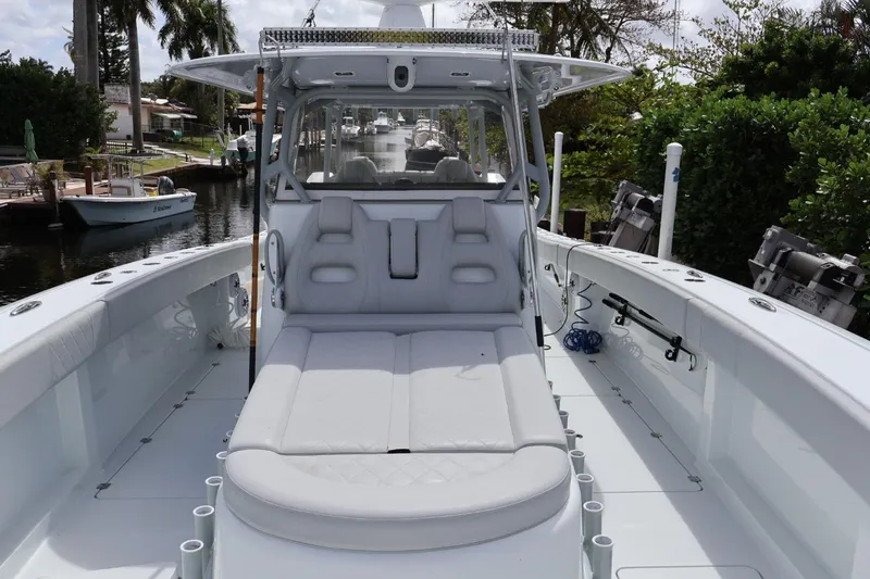 Slide: The Image of 2021 Freeman 42LR boat with spacious deck and seating, docked in a scenic canal. - 11