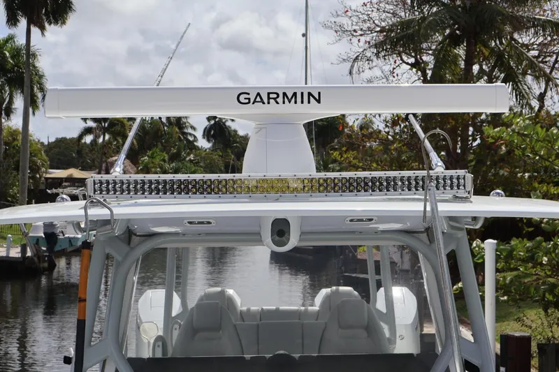 Slide: The Image of Freeman 42LR 2021 boat with Garmin radar and LED lights, docked near lush greenery. - 12