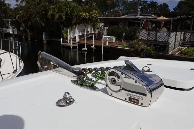 Slide: The Image of Freeman 42LR 2021 boat with anchor winch, docked near lush greenery. - 14