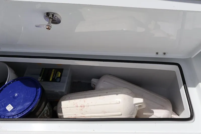 Slide: The Image of Storage compartment on a 2021 Freeman 42LR boat with various items inside. - 18
