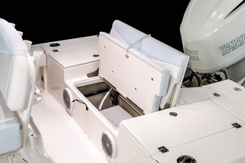 Slide: The Image of Manufacturer Provided Image: 2022 Robalo 246 Cayman boat with open storage compartments and Yamaha engine. - 11