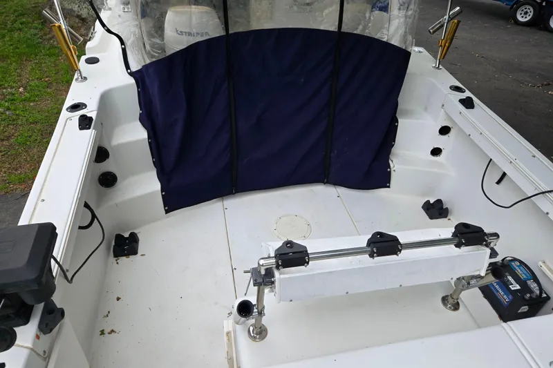 Slide: The Image of 2000 Seaswirl Striper 2300 boat interior with seating and fishing rod holders. - 5