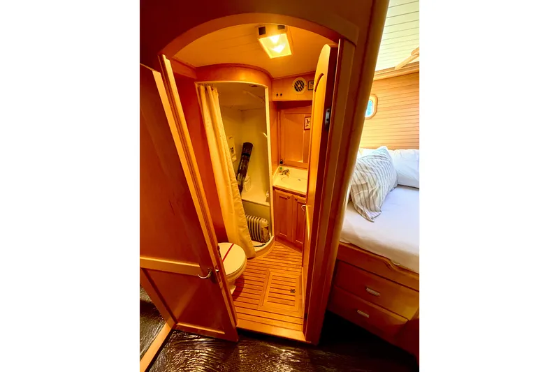 Slide: The Image of 1998 Waterline Pilothouse interior with wooden bathroom and cozy bedroom. - 13