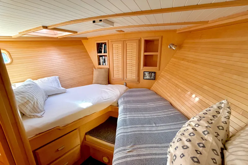 Slide: The Image of Cozy 1998 Waterline Pilothouse cabin interior with wooden paneling and twin beds. - 15