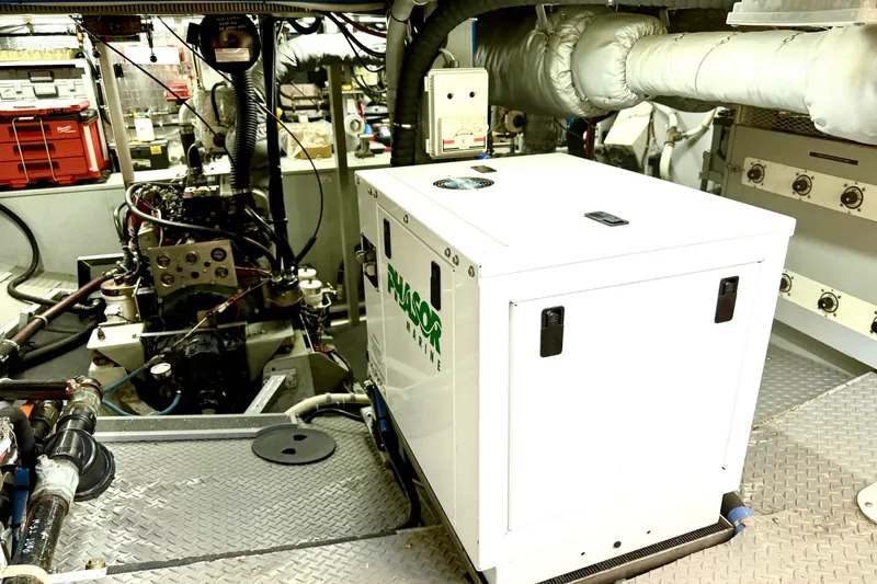 Slide: The Image of Engine room of a 1998 Waterline Pilothouse with generator and mechanical components. - 17