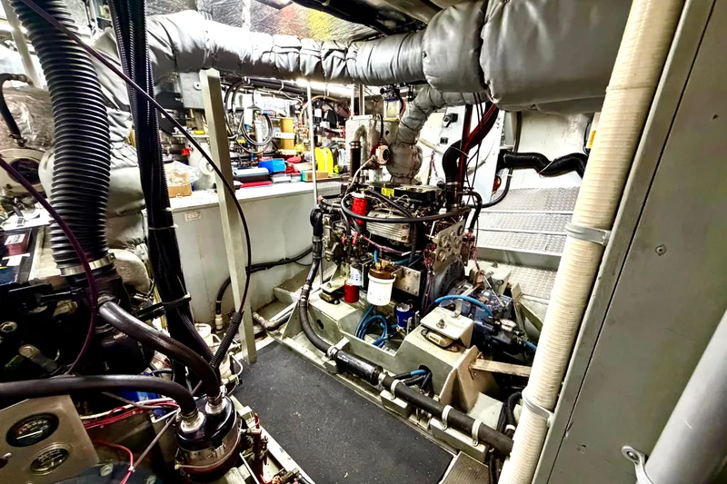 Slide: The Image of Engine room of a 1998 Waterline Pilothouse, showcasing complex machinery and piping. - 18