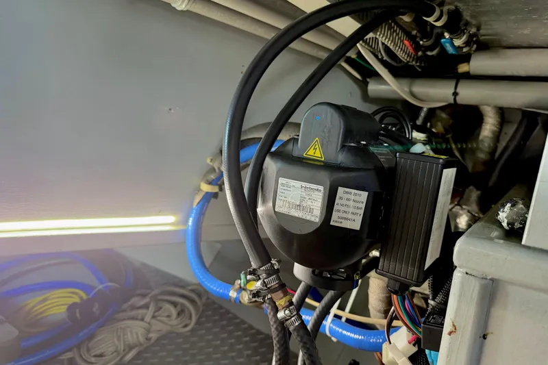 Slide: The Image of Engine room of a 1998 Waterline Pilothouse with visible wiring and components. - 21