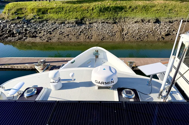 Slide: The Image of Bow view of a 1998 Waterline Pilothouse with Garmin equipment and solar panels. - 22