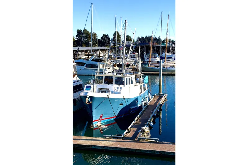 Slide: The Image of A 1998 Waterline Pilothouse boat docked in a marina under clear blue skies. - 4