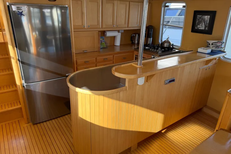 Slide: The Image of 1998 Waterline Pilothouse kitchen with wooden cabinetry, stainless steel fridge, and stove. - 5