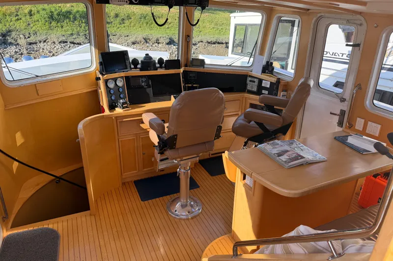 Slide: The Image of Pilothouse interior of a 1998 Waterline boat, featuring navigation equipment and seating. - 6